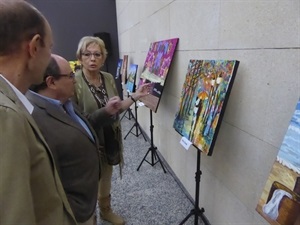 Isabel Marquina, directora de la Escuela de Arte, explica los cuadros de la exposición a Pedro Lloret, concejal de Cultura