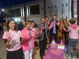Todos los participantes se han pintado las manos de rosa para dejar sus huellas en el lazo "por la vida" de AECC