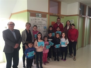 Los 9 alumnos premiados del II Concurso de Postales de Navidad junto a las representantes del AMPA, la directora y los concejales Pedro Lloret y Sergio Villalba.