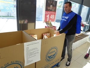 Bernabé Cano, alcalde de La Nucía, depositando comida no perecedera en uno de los supermercados
