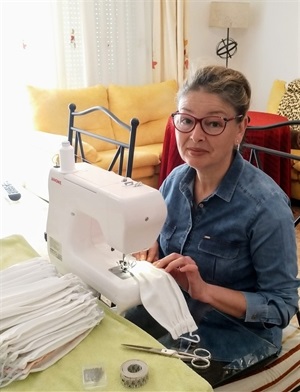 Salomé Jurado cose con su máquina de coser mientras que las telas las aportan empresas solidarias